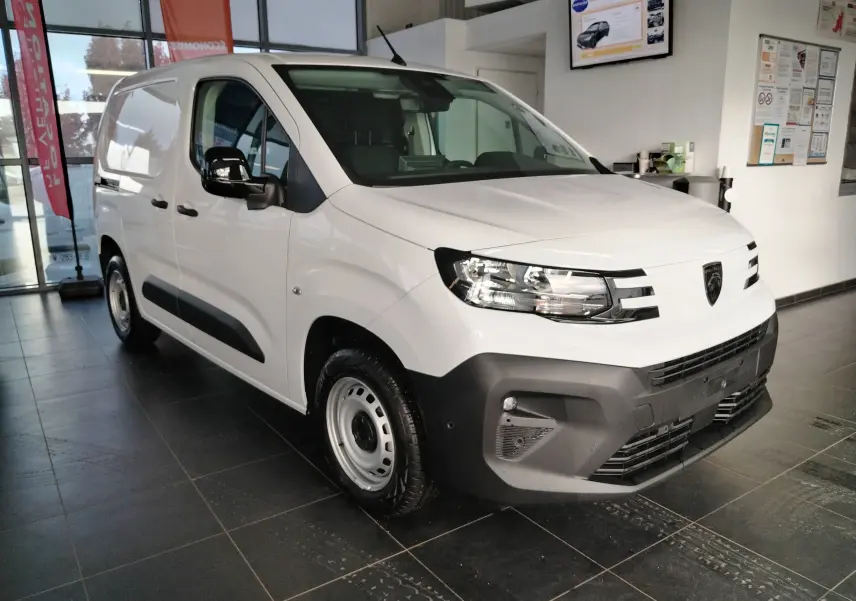 Vue 3/4 avant droit du Peugeot Partner FGN blanc Icy 2025 en showroom, avec pare-chocs noir et jantes acier.