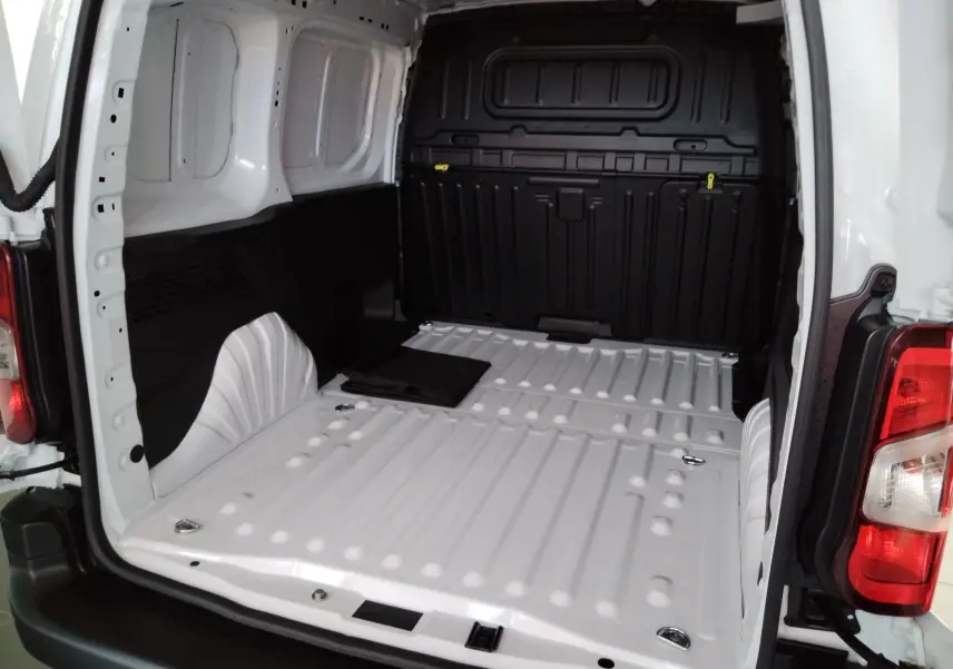 Vue intérieure arrière du coffre blanc Icy du Peugeot Partner FGN 2025, avec plancher métallique et anneaux d'arrimage visibles.