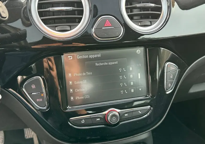 Écran tactile central de l’Opel Adam 2016 avec commandes de gestion Bluetooth et boutons de fonction noirs brillants.