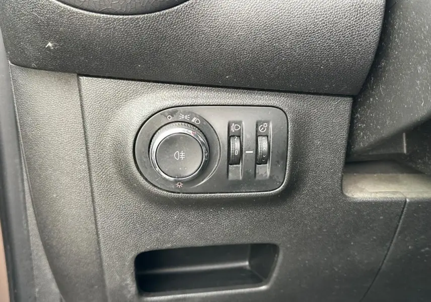 Gros plan sur le panneau de commande des phares et réglages d'éclairage intérieur de l'Opel Adam marron 2016.