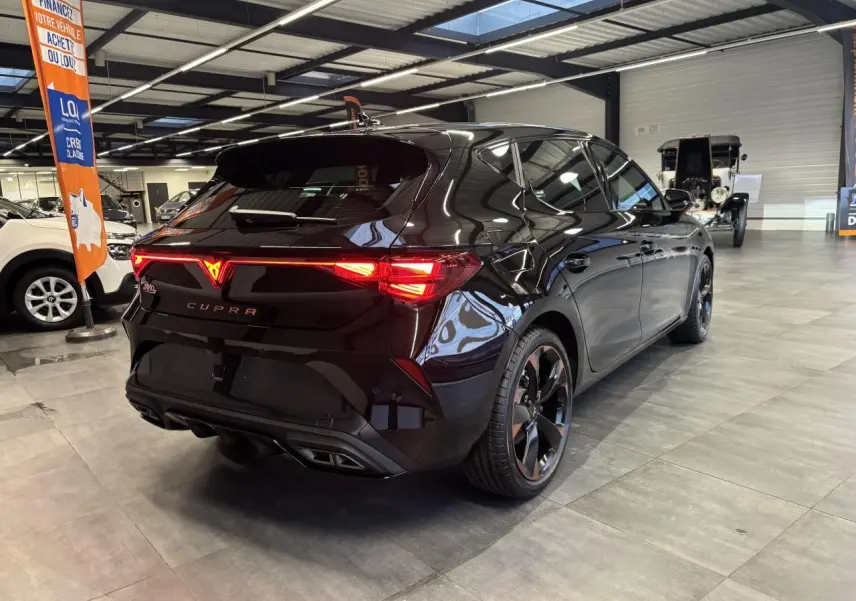 Vue 3/4 arrière droite de la CUPRA Leon noir midnight avec feux arrière Tri-LED et jantes alliage 18'' cuivrées.