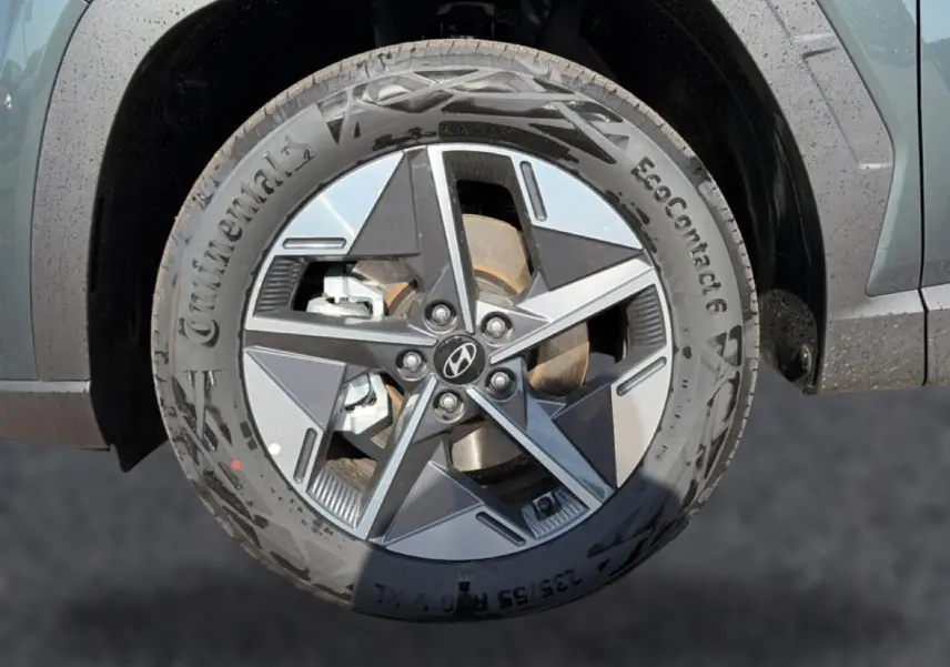 Gros plan sur la roue avant droite du Hyundai Tucson vert 2026 avec jante alliage 18 pouces et logo Hyundai au centre.