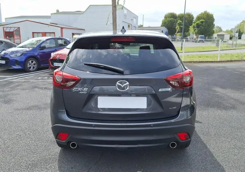 Vue arrière d'un Mazda CX-5 gris 2015 avec double sortie d'échappement et feux rouges distinctifs.