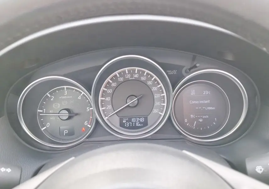 Tableau de bord du Mazda CX-5 gris 2015, vue frontale sur compte-tours, vitesse et écran multifonction.