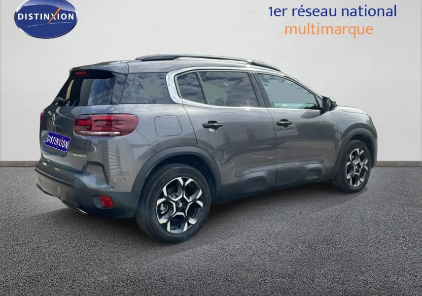 Vue 3/4 arrière droite d'un Citroën C5 Aircross Hybrid gris platinium métallisé avec jantes bi-ton et toit panoramique.