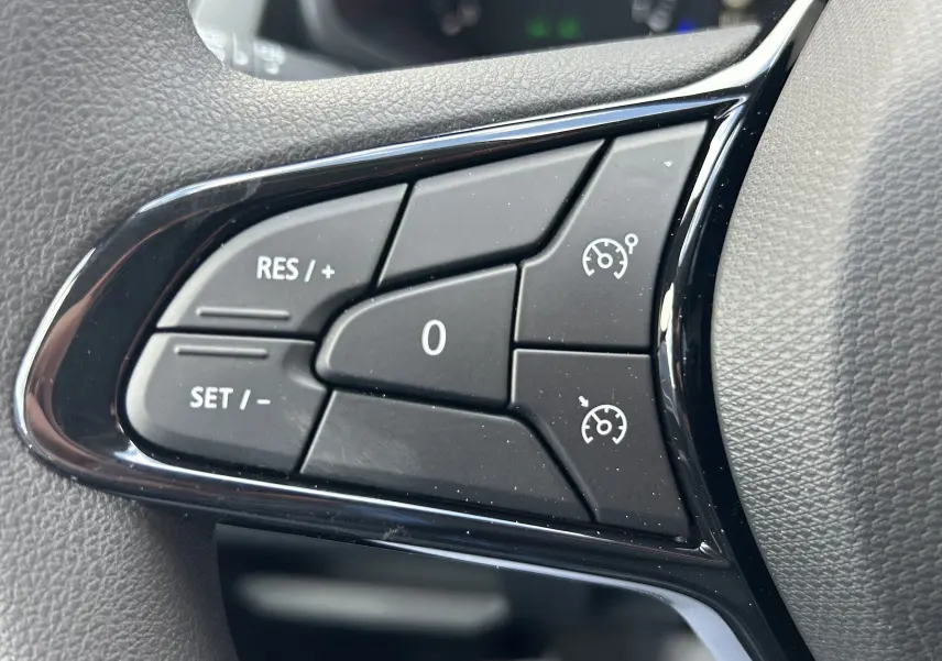 Gros plan sur les commandes de régulateur de vitesse au volant du Renault Trafic Fourgon L1H1 gris Highland.