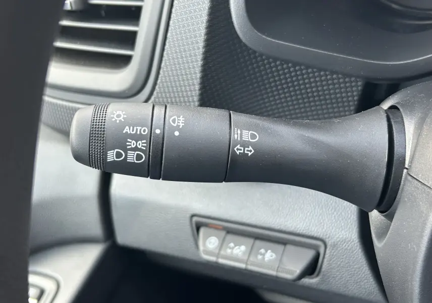 Gros plan sur la commande des phares et clignotants du Renault Trafic Fourgon L1H1 gris Highland, intérieur tableau de bord.