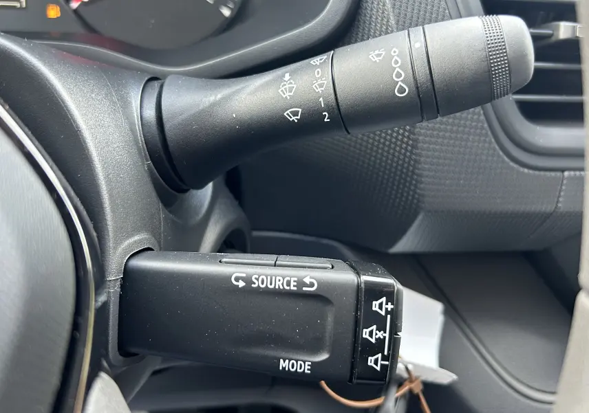 Gros plan sur la commande multimédia au volant du Renault Trafic Fourgon gris Highland, côté gauche du tableau de bord.