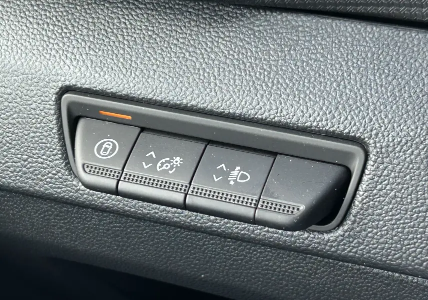 Boutons de réglage d'éclairage et verrouillage sur tableau de bord noir du Renault Trafic Fourgon gris Highland.