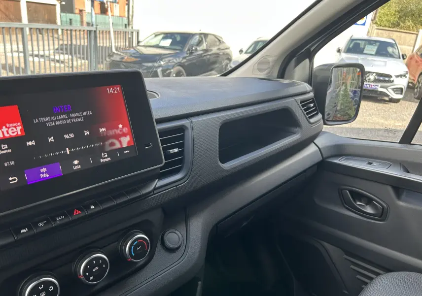 Intérieur du Renault Trafic Fourgon L1H1 Advance 2025, vue du tableau de bord côté passager avec écran tactile et commandes climatisation.