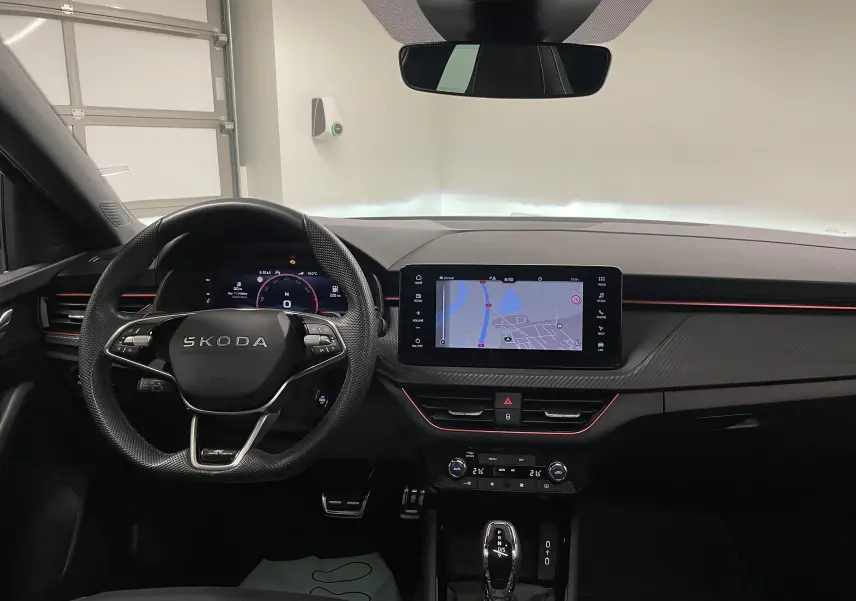 Intérieur de la Skoda Scala 1.5 TSI Monte-Carlo 2025, vue frontale du tableau de bord noir avec écran tactile et volant multifonction.