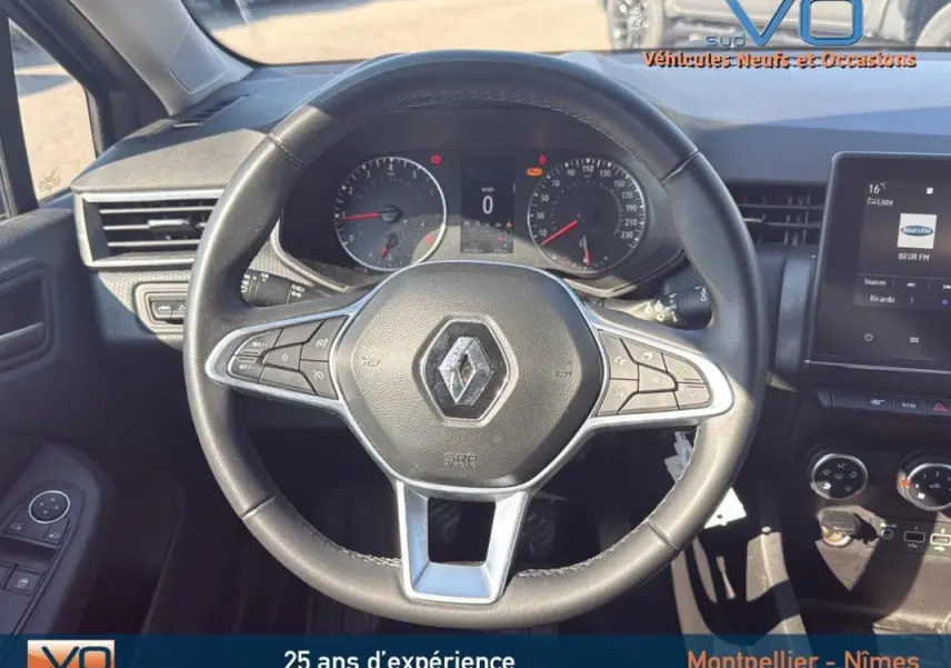 Vue rapprochée du volant noir de la Renault Clio V TCe 90 Equilibre 2022 avec tableau de bord et écran tactile visibles.