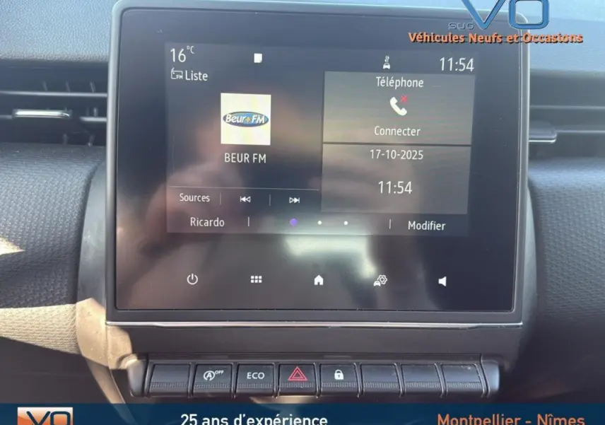 Écran tactile central de la Renault Clio gris 2022 affichant radio Beur FM et commandes de climatisation manuelle.