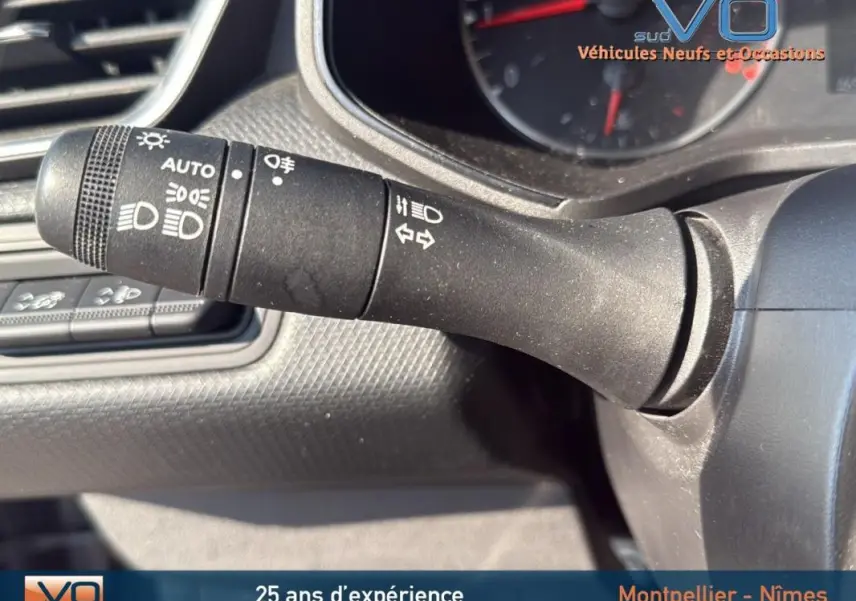 Gros plan sur la commande des phares et clignotants dans l'habitacle d'une Renault Clio gris 2022.