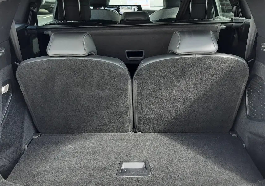 Vue arrière du coffre ouvert du Peugeot 5008 gris titane, montrant les sièges arrière et l'espace de chargement.