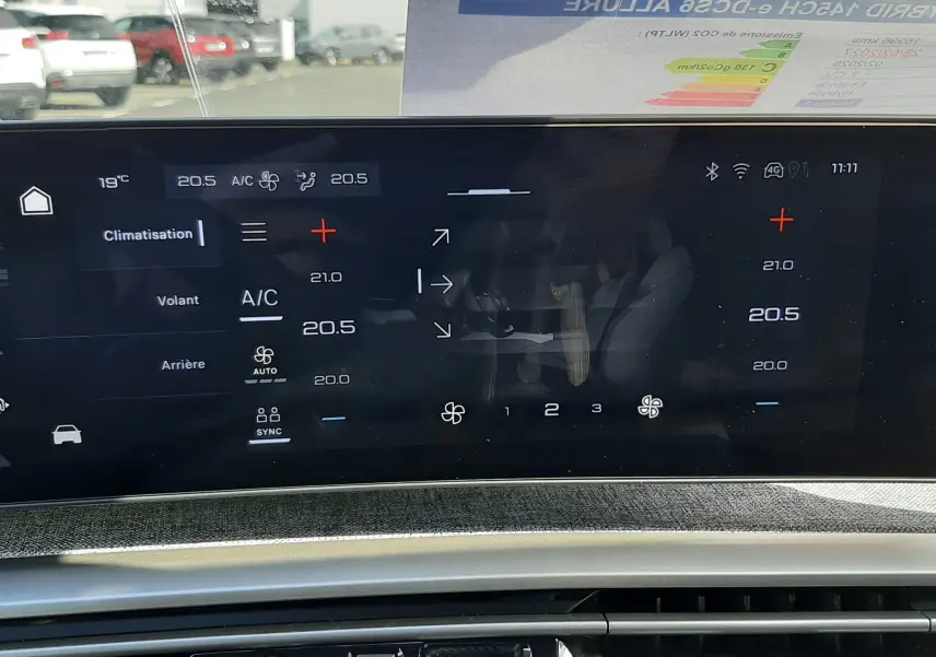Vue rapprochée de l’écran tactile central et console d’une Peugeot 5008 Hybrid 145ch gris titane, avec affichage de la climatisation.