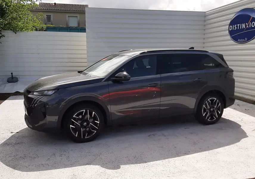 Peugeot 5008 Hybrid gris titane métal vue de profil côté gauche, avec jantes alliage noires et toit panoramique.