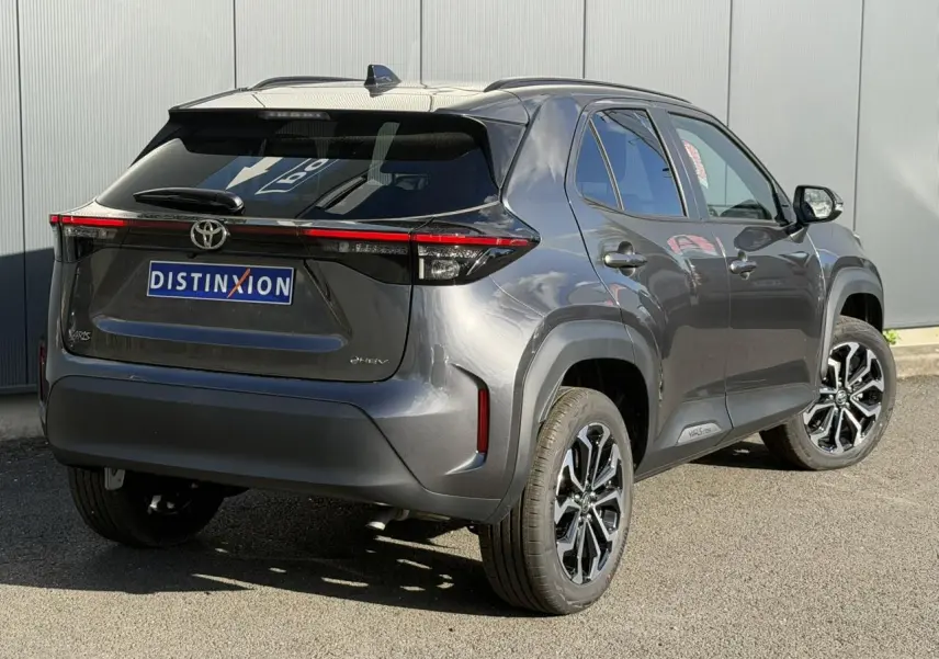 Vue 3/4 arrière droite d'une Toyota Yaris Cross 2026 gris Atlas avec jantes alliage 17 pouces et antenne aileron de requin.
