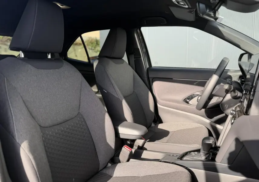 Vue intérieure côté droit des sièges avant gris clair et tableau de bord de la Toyota Yaris Cross 2026.
