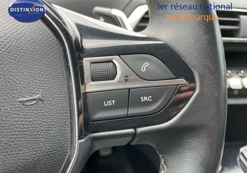 Gros plan sur les commandes gauche du volant noir du Peugeot 3008 gris, avec boutons LIST, SRC et téléphone.