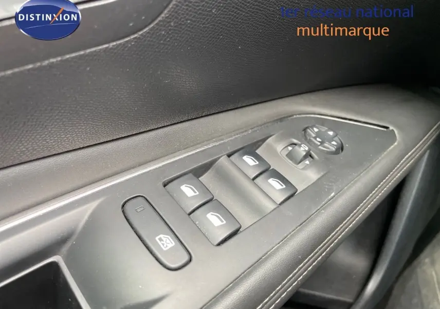 Gros plan sur les commandes de lève-vitres et réglage des rétroviseurs sur la porte côté gauche d’un Peugeot 3008 gris.
