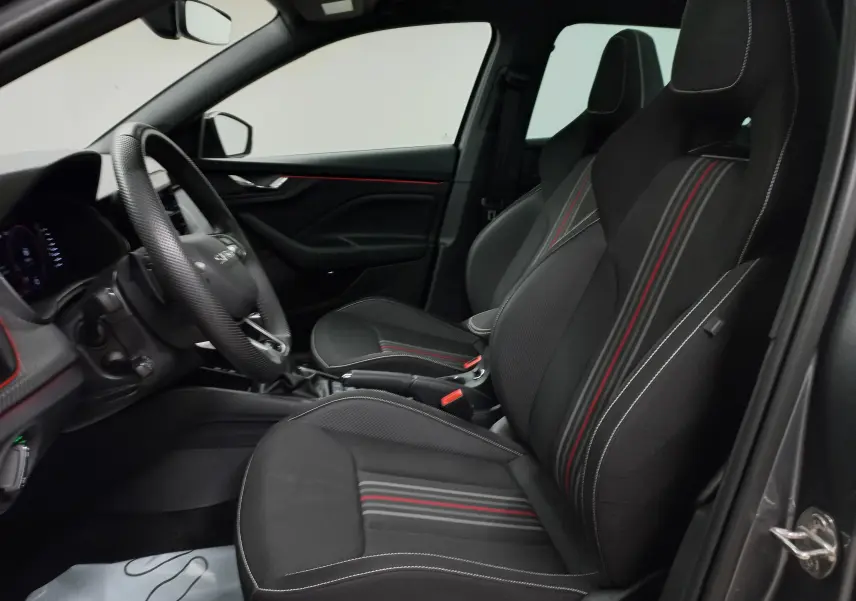 Vue intérieure côté conducteur de la Skoda Scala Monte-Carlo 2025 avec sièges noirs à surpiqûres rouges et blanches.