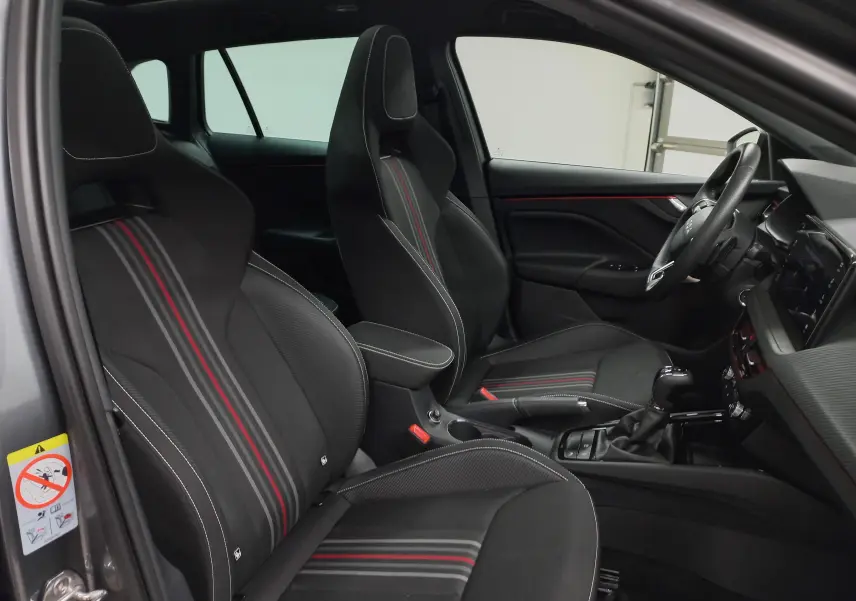 Intérieur de la SKODA SCALA 1.5 TSI Monte-Carlo vu côté conducteur, sièges noirs avec bandes rouges et coutures blanches.