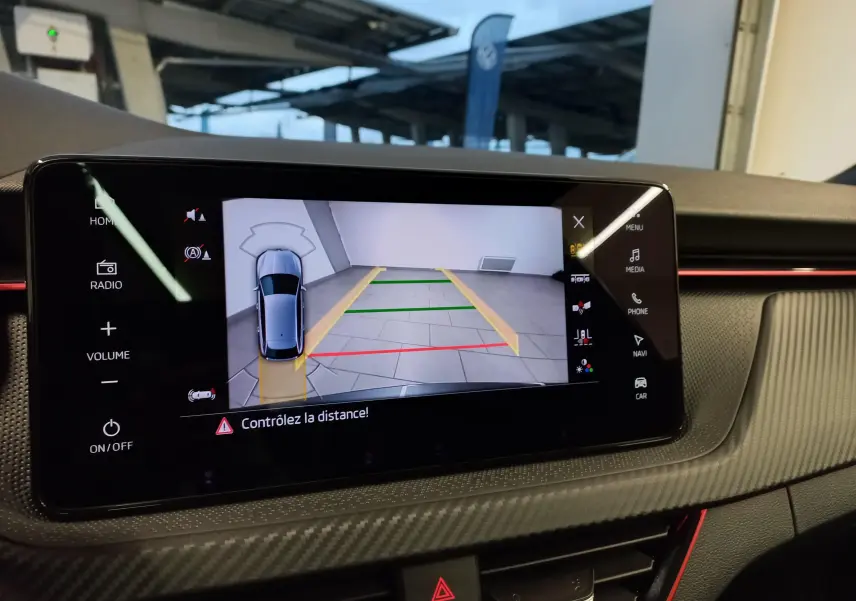 Écran tactile intérieur montrant la caméra de recul avec vue 3D du Skoda Scala Gris Graphite en stationnement.