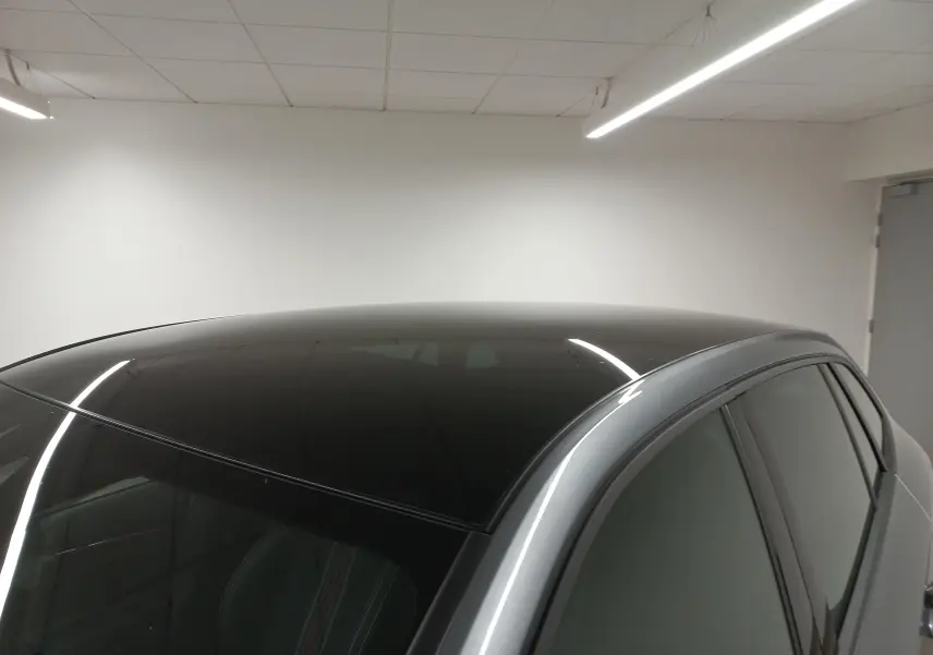 Toit panoramique noir brillant et partie supérieure gris graphite d'une Skoda Scala 2025 vue côté droit en intérieur.