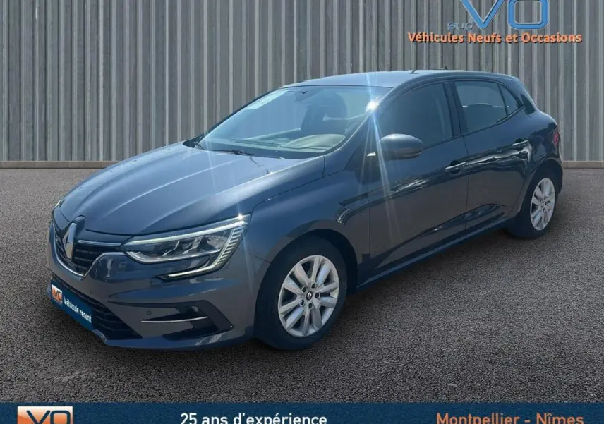 Renault Mégane IV Berline gris vue 3/4 avant droit avec jantes 16 pouces et phares LED allumés.