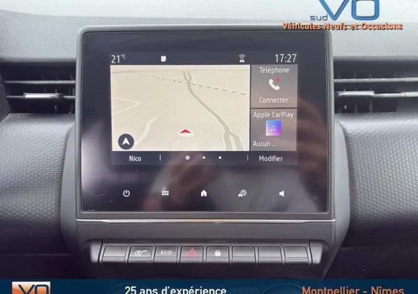 Écran tactile central avec navigation et commandes dans l’habitacle d’une Renault Clio gris foncé, vue de face.