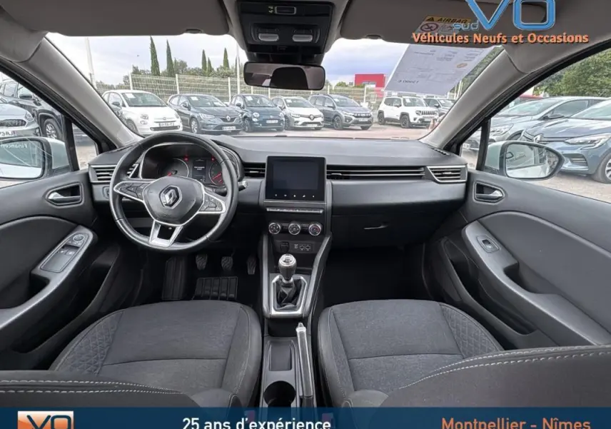 Vue intérieure avant de la Renault Clio gris foncé 2020, avec volant multifonction et boîte manuelle visible.