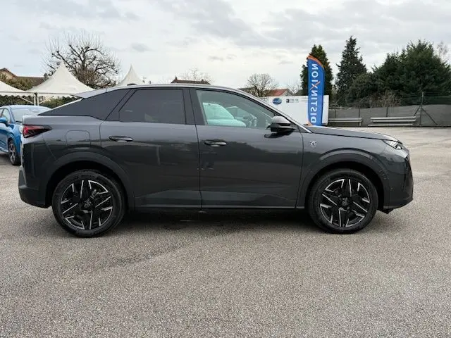 Vue latérale droite du Peugeot 3008 Hybrid 145 GT gris titane avec jantes alliage noires bicolores et toit noir.
