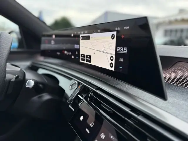 Vue intérieure rapprochée du tableau de bord du Peugeot 3008 Hybrid 145 GT avec écran panoramique incurvé HD et finition aluminium.