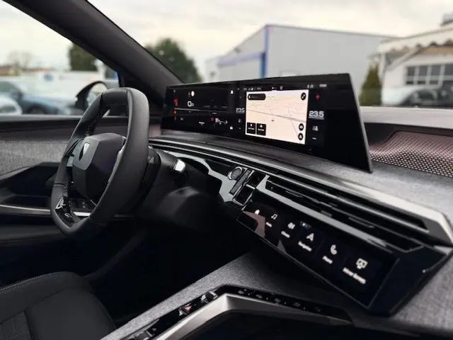 Vue intérieure côté conducteur du Peugeot 3008 Hybrid 145 GT 2025, écran panoramique incurvé HD et volant cuir multifonction.