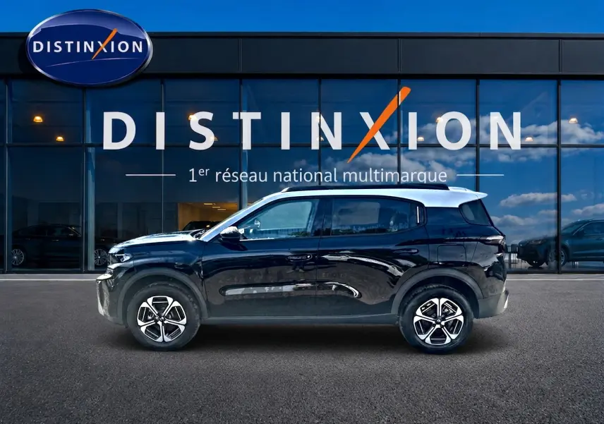 Profil droit d'un Citroën C3 Aircross noir 2026 devant une vitrine avec logo Distinxion.