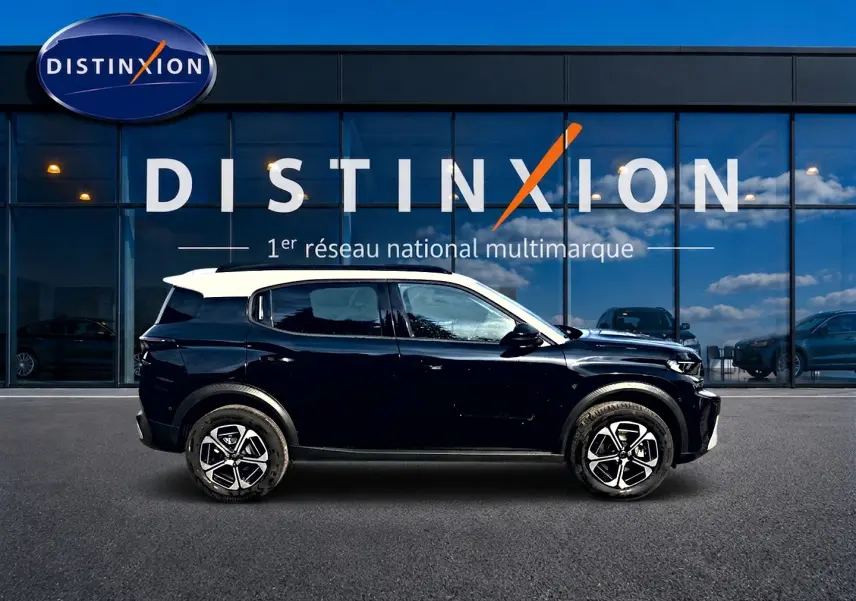 Profil côté gauche d'un Citroën C3 Aircross noir avec toit blanc, jantes alu et barres de toit visibles.