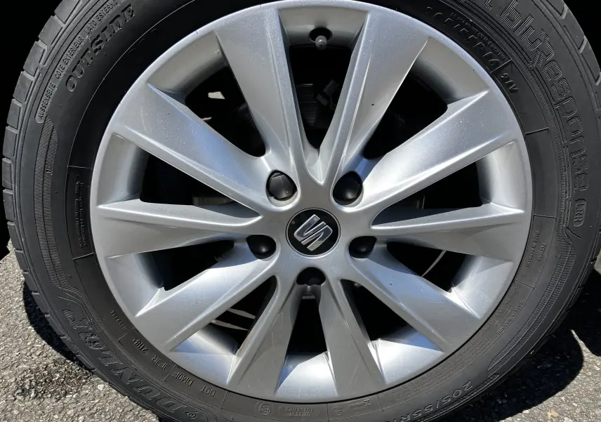 Gros plan sur la jante argentée à 10 branches avec logo SEAT central, montée sur pneu Dunlop noir.