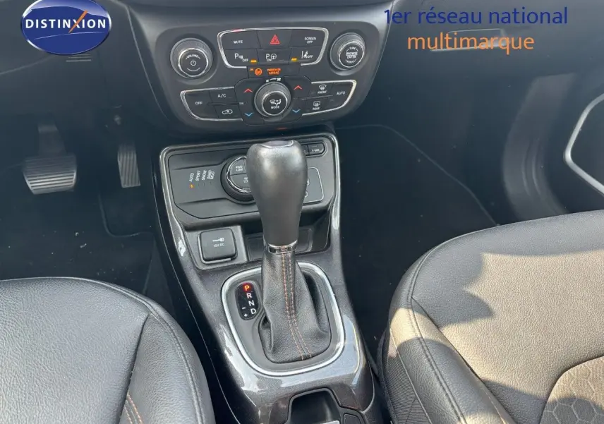 Le levier de vitesses automatique et la console centrale du Jeep Compass blanc, avec sièges en cuir noir visibles de près.