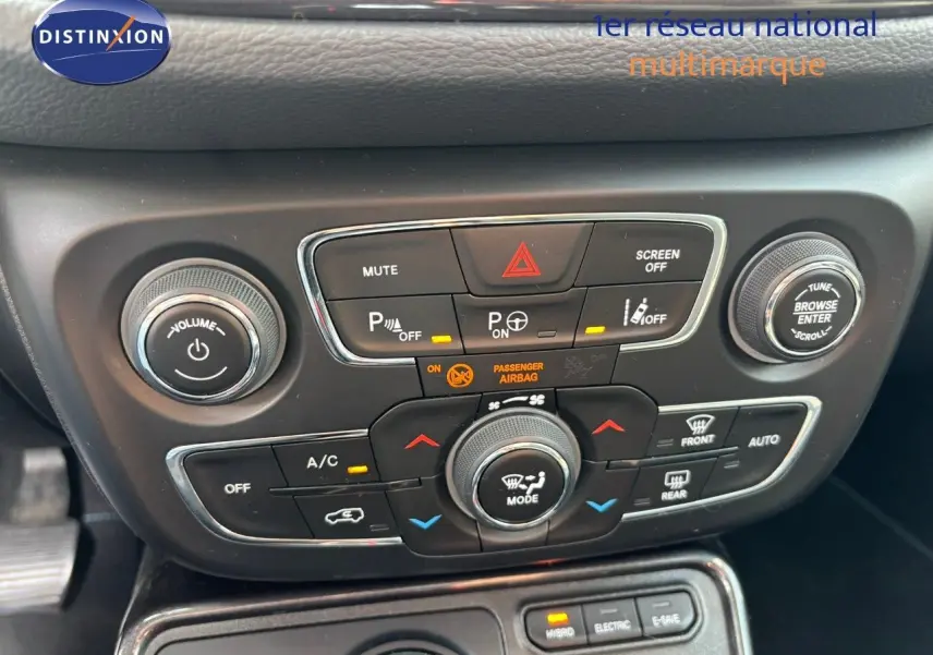 Gros plan sur la console centrale noire du Jeep Compass hybride rechargeable 2021, montrant les commandes de climatisation et audio.