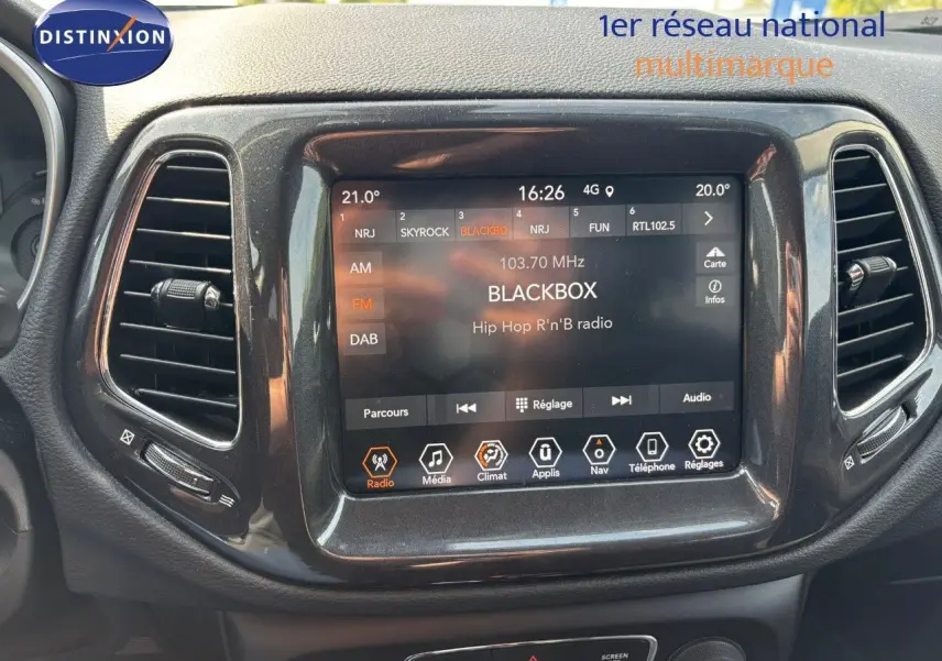 Écran tactile central du tableau de bord du Jeep Compass blanc 2021 affichant une radio Hip Hop R'n'B.