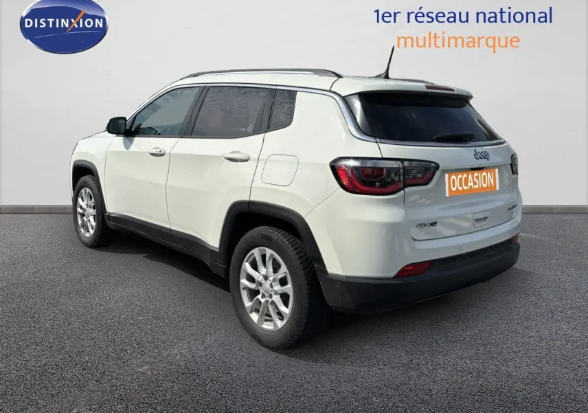 Jeep Compass blanc en 3/4 arrière côté gauche, SUV hybride rechargeable avec jantes alliage et toit noir.