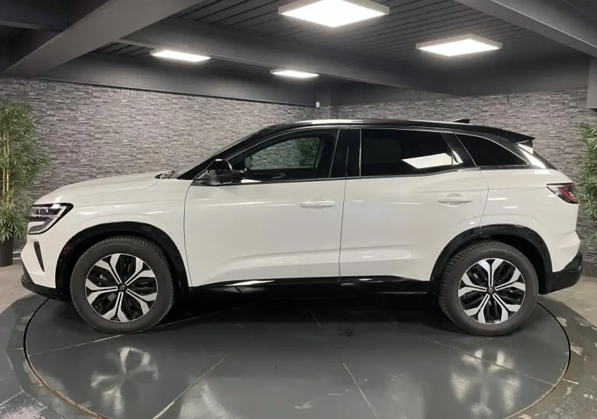 Profil côté gauche du Renault Austral blanc nacré avec toit noir étoilé et jantes alliage 18'' altao diamantées noir.