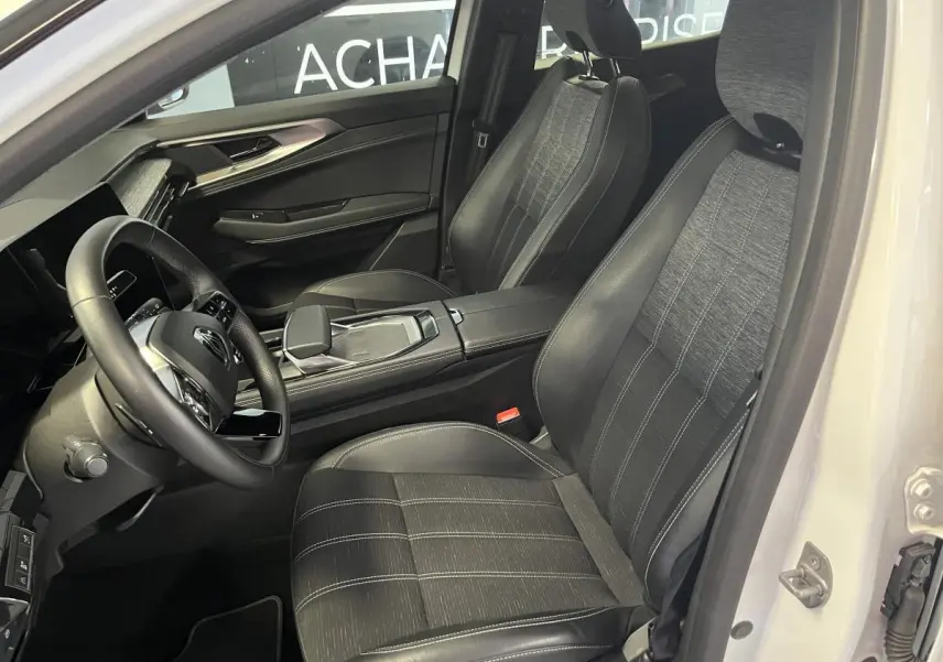 Intérieur noir et gris du Renault Austral 2024, vue côté conducteur avec sièges en simili-cuir et volant textile.