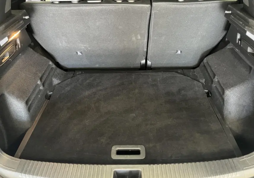 Coffre ouvert vu de l'arrière d'un Renault Austral 2024 blanc, montrant l'espace de chargement et banquette arrière rabattue.