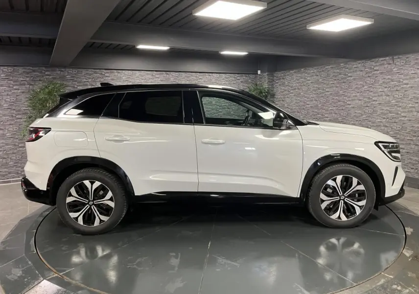 Profil droit du Renault Austral blanc nacré 2024 avec toit noir étoilé et jantes alliage 18'' altao diamantées noir.
