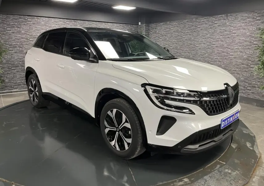 Renault Austral blanc nacré vu en 3/4 avant droit avec toit noir étoilé et jantes alliage 18 pouces.