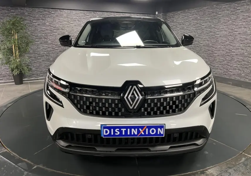 Vue frontale du Renault Austral blanc nacré 2024 avec calandre damier noire et logo Renault proéminent.