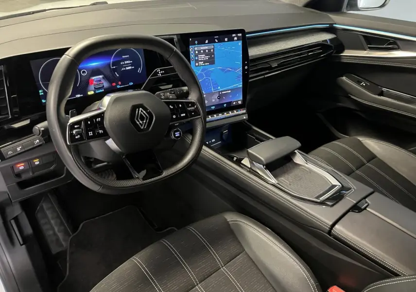Intérieur du Renault Austral 2024 vu côté conducteur, tableau de bord numérique et écran tactile central lumineux.