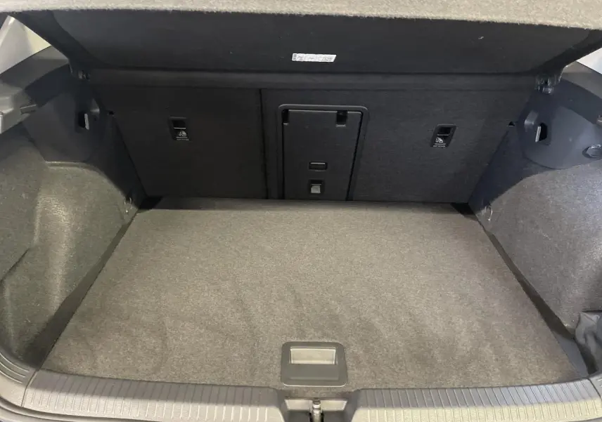 Coffre ouvert de la Volkswagen Golf 1.5 eTSI Style 2024 noir, montrant l'espace de chargement et la banquette arrière rabattable.